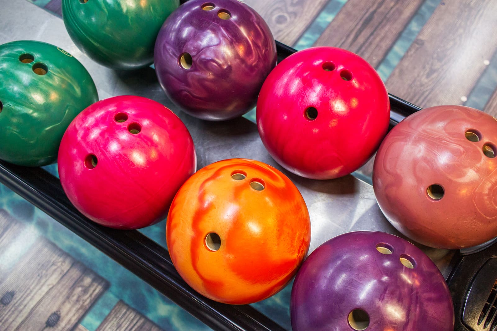 Various colored bowling balls in holder
